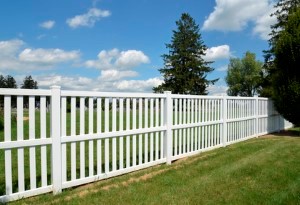 White vinyl fence by green lawn